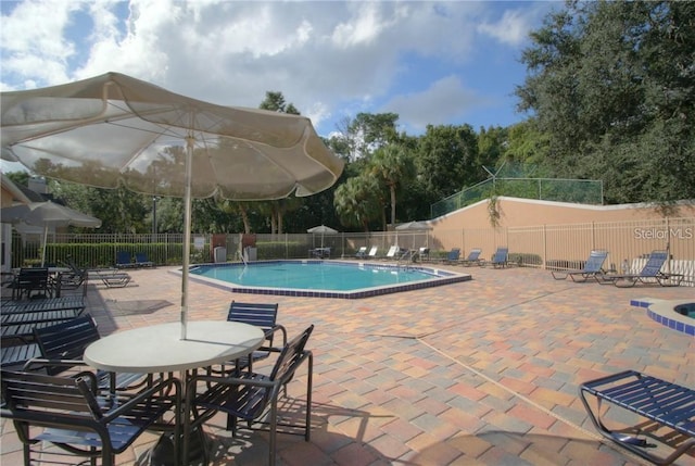 community pool with fence and a patio