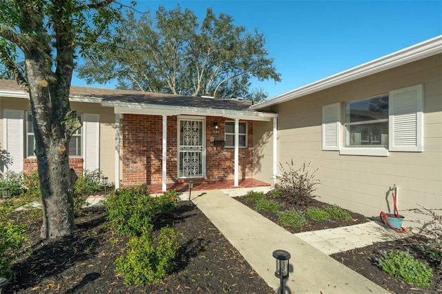 view of exterior entry featuring brick siding