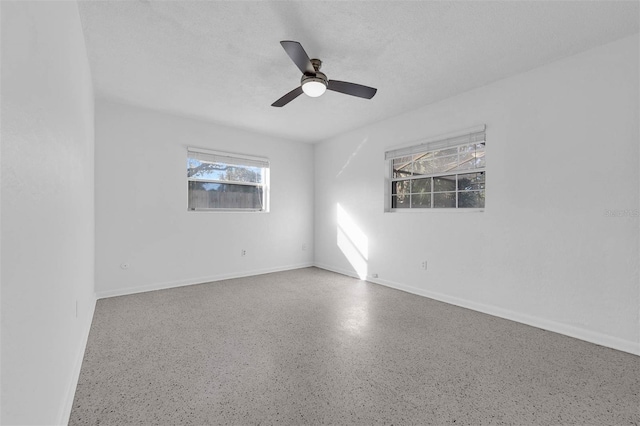 unfurnished room featuring a ceiling fan, baseboards, and a textured ceiling