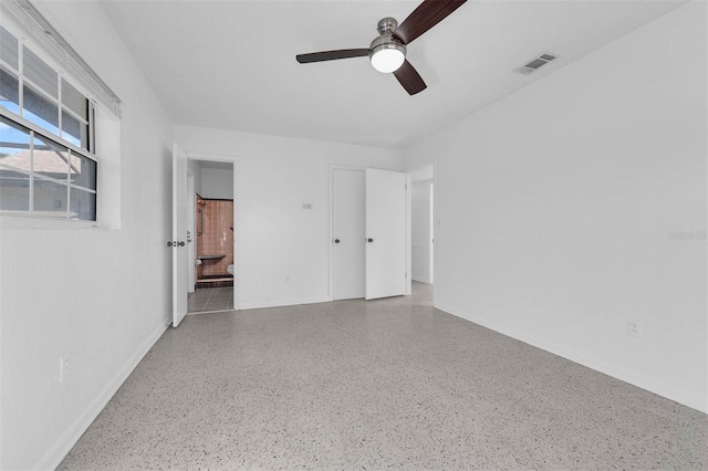 unfurnished bedroom featuring visible vents, ceiling fan, ensuite bathroom, and speckled floor