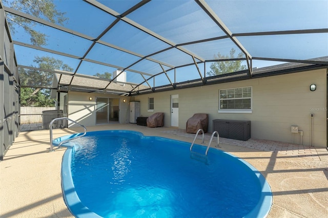 pool with a lanai, fence, and a patio