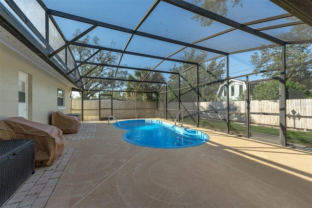 view of swimming pool with a fenced in pool, glass enclosure, a patio, and a fenced backyard