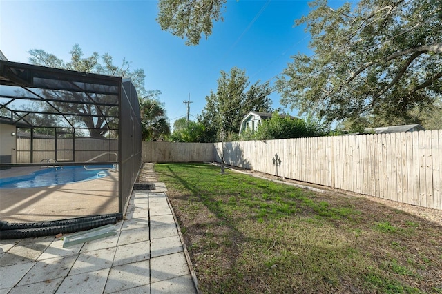 view of yard with a lanai, a fenced backyard, a fenced in pool, and a patio