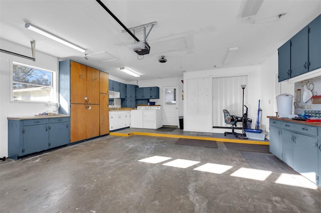 garage with washing machine and clothes dryer and a garage door opener