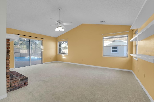 empty room with light colored carpet, vaulted ceiling, a textured ceiling, ceiling fan, and baseboards