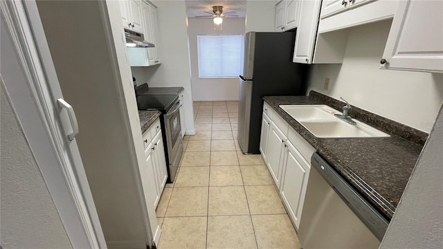 kitchen with appliances with stainless steel finishes, sink, light tile patterned floors, and white cabinets