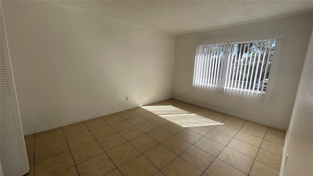 tiled spare room with a textured ceiling