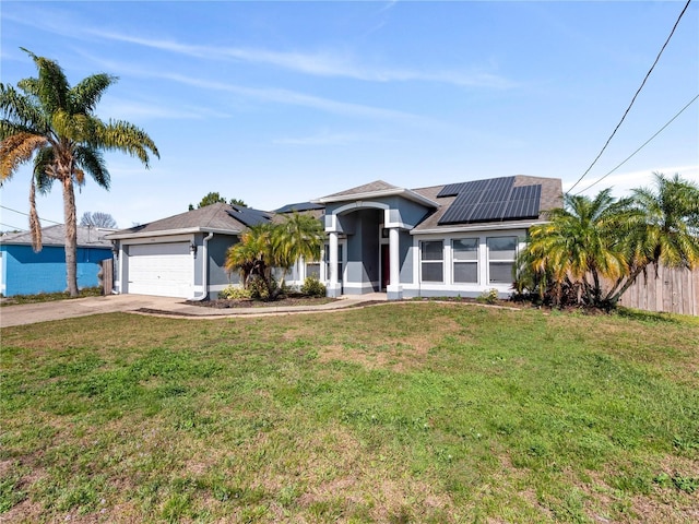 view of front of property with a garage, a front lawn, and solar panels