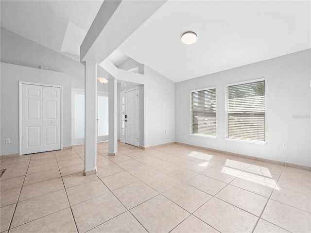 tiled empty room with vaulted ceiling