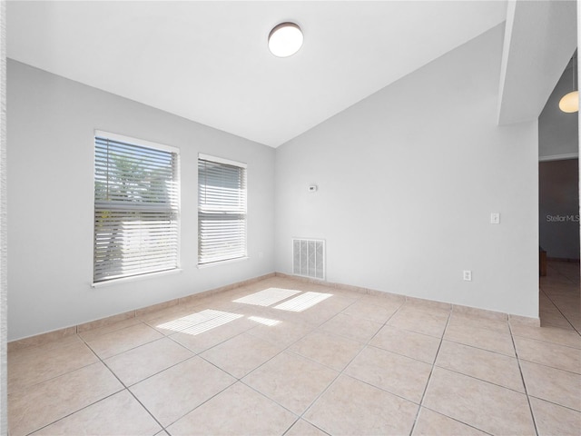 unfurnished room featuring light tile patterned flooring and vaulted ceiling