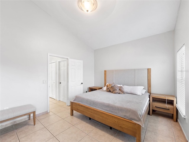 tiled bedroom featuring multiple windows and lofted ceiling