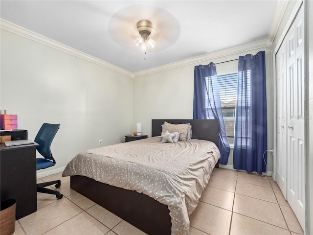 tiled bedroom featuring ornamental molding, ceiling fan, and a closet