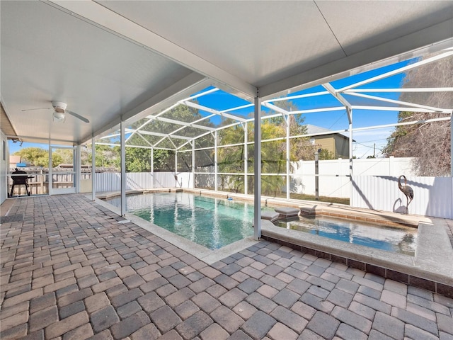 view of pool featuring an in ground hot tub, a patio, ceiling fan, and glass enclosure