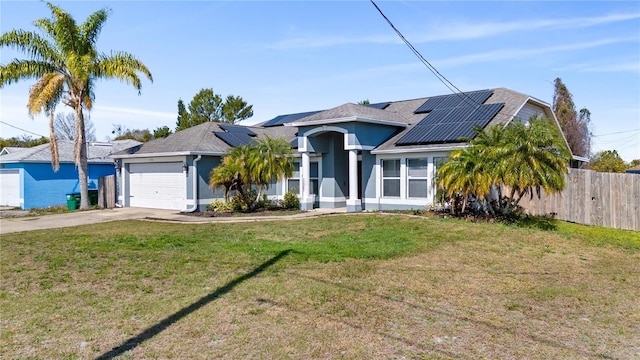 view of front facade with a garage, a front yard, and solar panels