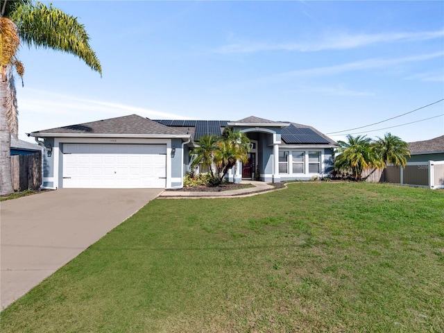 single story home with a garage, a front lawn, and solar panels