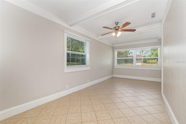 tiled empty room with beamed ceiling, ceiling fan, and a textured ceiling