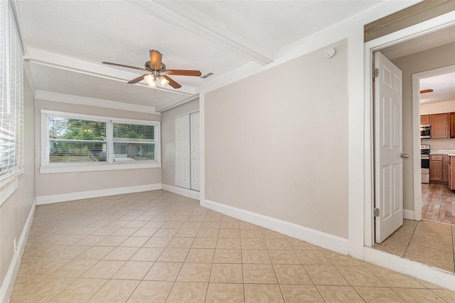 tiled spare room featuring beamed ceiling, ceiling fan, and a textured ceiling