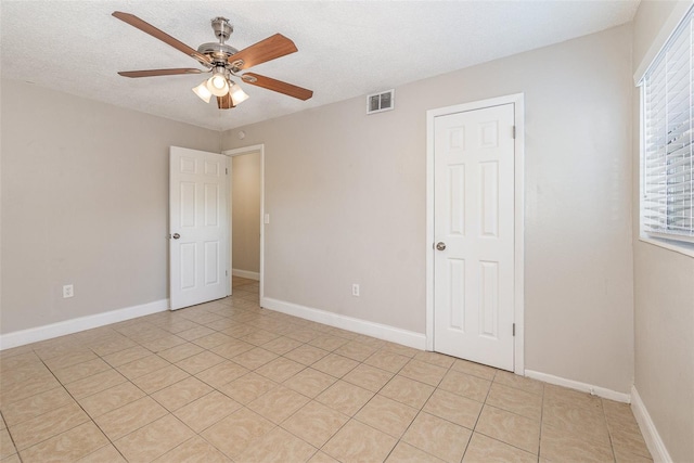 unfurnished room featuring ceiling fan and a textured ceiling