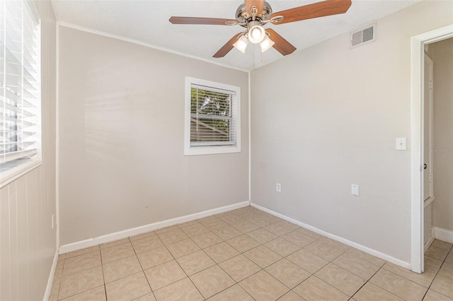 tiled empty room featuring ceiling fan