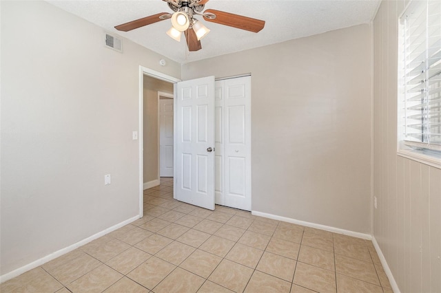 unfurnished bedroom with a closet, ceiling fan, and light tile patterned flooring