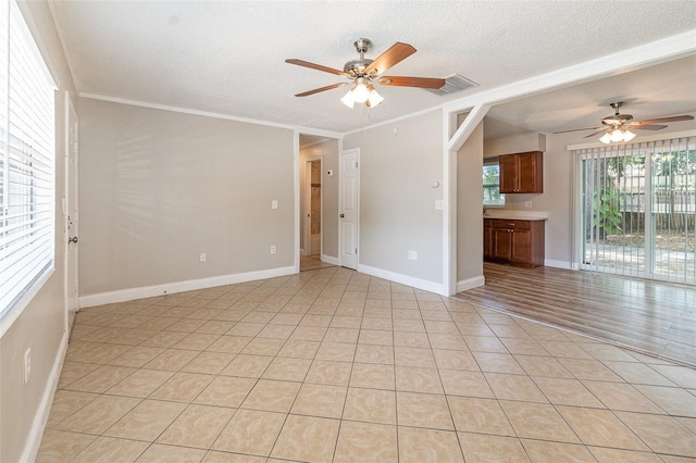 unfurnished room featuring crown molding, light tile patterned floors, ceiling fan, and a textured ceiling