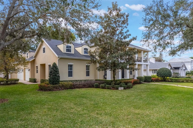 view of front of property with a garage, a front yard, a balcony, and stucco siding