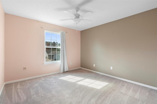 empty room featuring light carpet, a textured ceiling, and ceiling fan