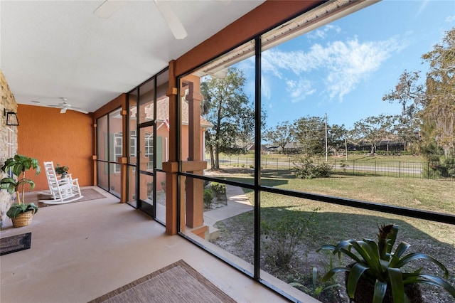 unfurnished sunroom featuring ceiling fan