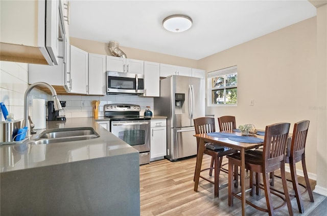 kitchen with white cabinetry, sink, tasteful backsplash, and stainless steel appliances