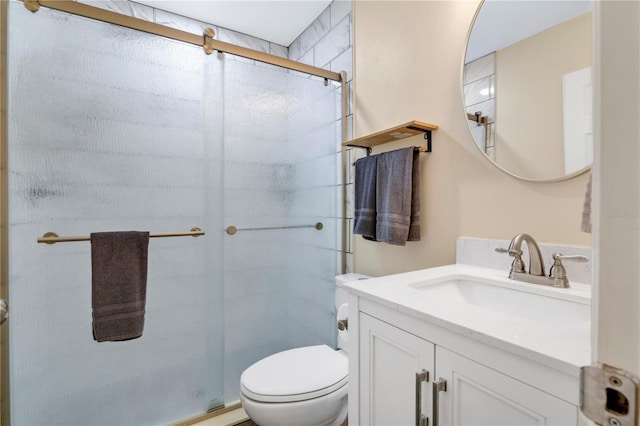 bathroom with vanity, a shower with shower door, and toilet