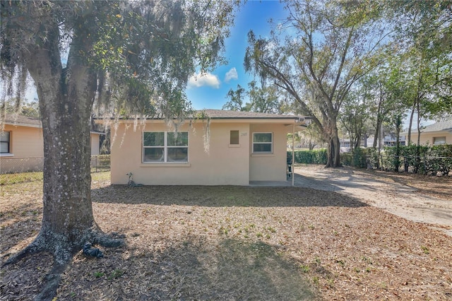 203 N Blvd E, Davenport, FL 33837 - back of house featuring stucco siding, concrete driveway, and fence