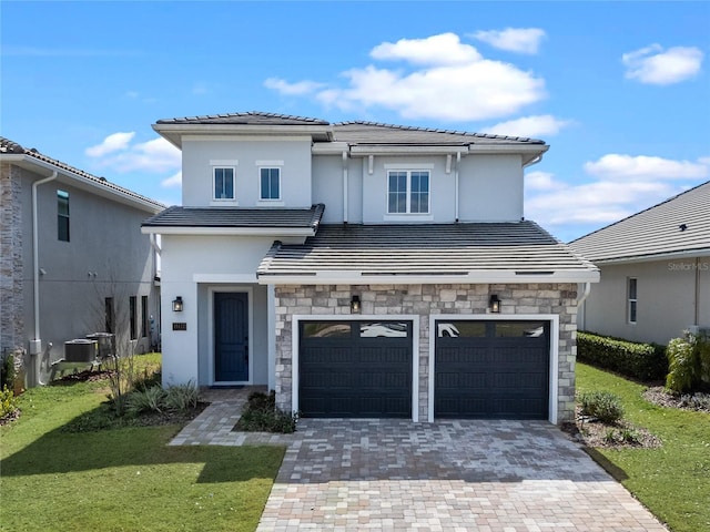 view of front of house featuring a garage, central AC unit, and a front lawn