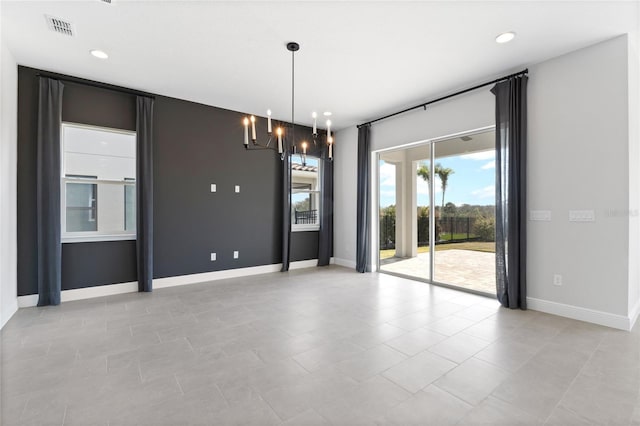 spare room with a notable chandelier