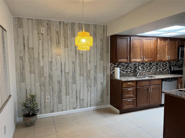 kitchen featuring sink, hanging light fixtures, light tile patterned floors, stainless steel appliances, and decorative backsplash