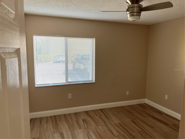 spare room with hardwood / wood-style floors, a textured ceiling, and ceiling fan