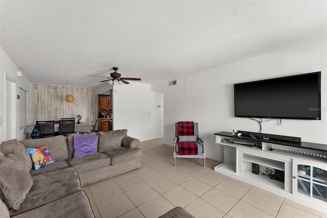 5201 Vineland Rd Unit 112, Orlando, FL 32811 - living area with wooden walls, visible vents, light tile patterned flooring, a textured ceiling, and ceiling fan