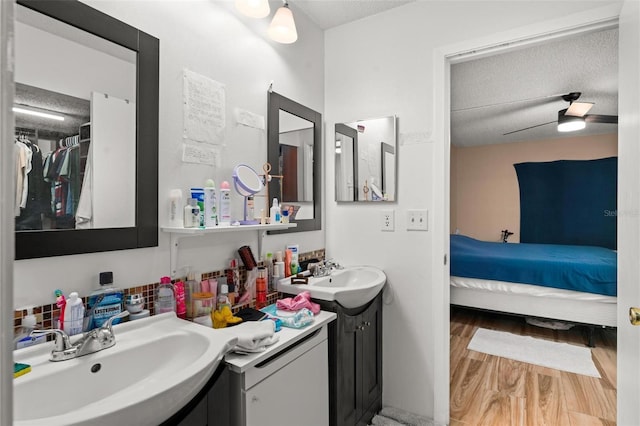 5201 Vineland Rd Unit 112, Orlando, FL 32811 - ensuite bathroom with ensuite bath, wood finished floors, a sink, and a textured ceiling