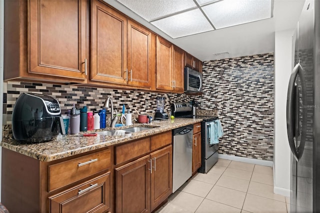 5201 Vineland Rd Unit 112, Orlando, FL 32811 - kitchen featuring stainless steel appliances, a sink, visible vents, brown cabinetry, and light tile patterned floors