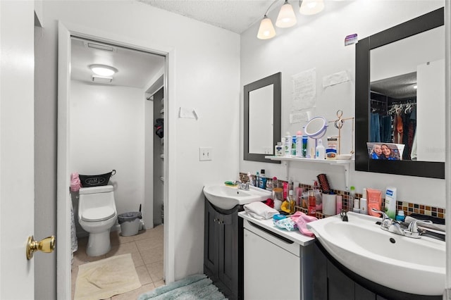 5201 Vineland Rd Unit 112, Orlando, FL 32811 - full bathroom featuring a walk in closet, two vanities, tile patterned floors, and a sink