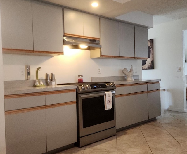 kitchen featuring stainless steel range oven and light tile patterned flooring