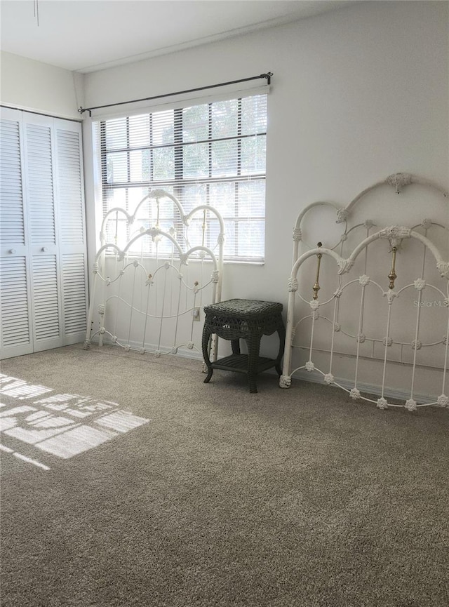 carpeted bedroom featuring multiple windows and a closet