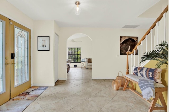 11419 Donneymoor Dr, Riverview, FL 33569 - foyer with arched walkways, light tile patterned floors, stairs, and french doors