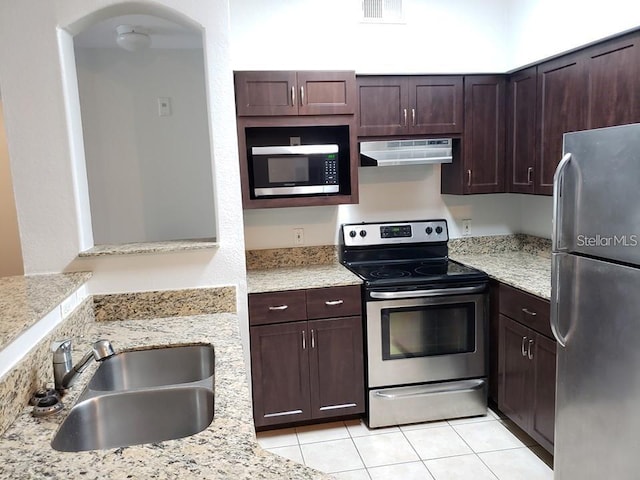 kitchen featuring appliances with stainless steel finishes, sink, light tile patterned floors, and light stone counters