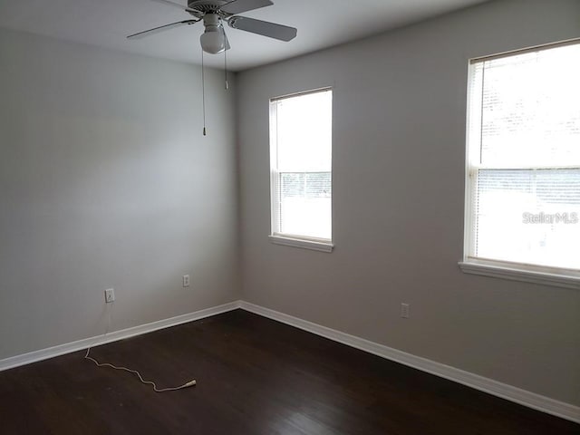 empty room featuring dark wood-type flooring and ceiling fan