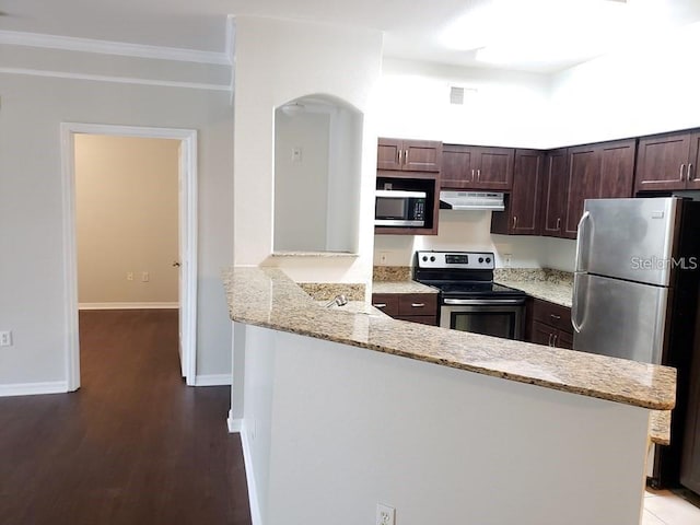 kitchen with kitchen peninsula, stainless steel appliances, crown molding, light stone countertops, and dark brown cabinets