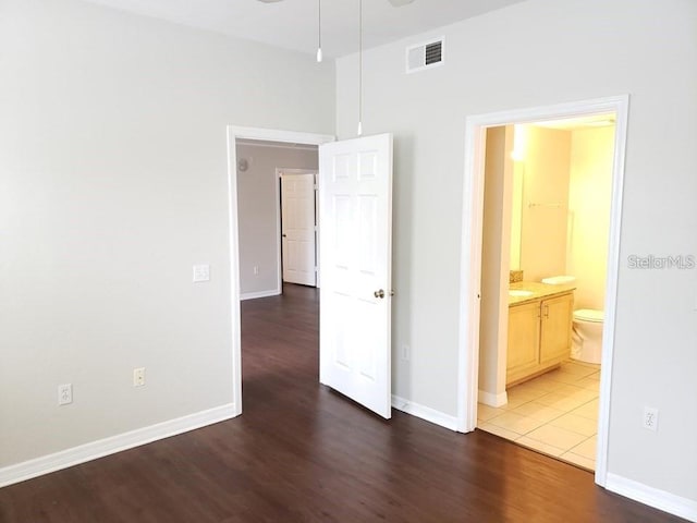 interior space with ensuite bath and dark hardwood / wood-style floors