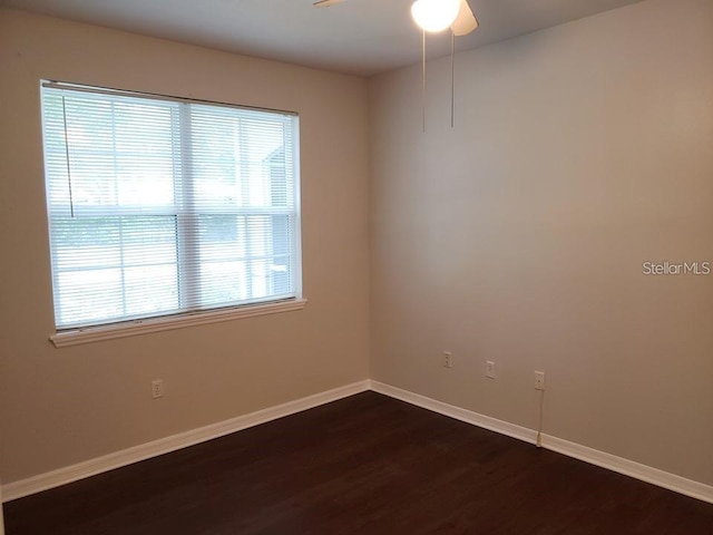 spare room with dark hardwood / wood-style flooring and ceiling fan