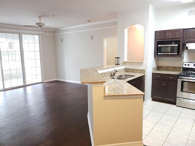 kitchen featuring sink, crown molding, kitchen peninsula, stainless steel appliances, and light stone countertops