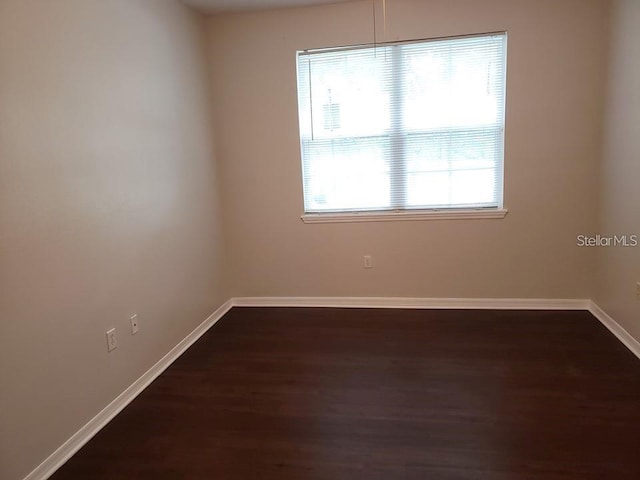 spare room with dark hardwood / wood-style floors