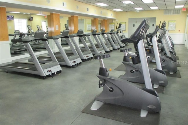 gym with a paneled ceiling